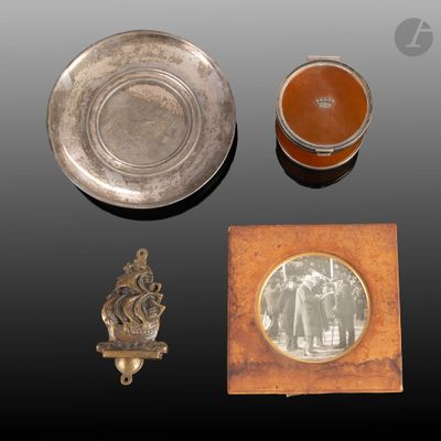 une photo représentant un ensemble d'objets, notamment un plat en argent, un cadre photo et la photo d'un homme