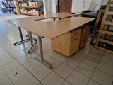 a wooden desk with a metal base in the middle of a room