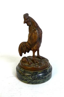statue d'un coq posée sur un socle en marbre, sur fond blanc
