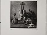 photographie en noir et blanc représentant une nature morte avec un violon et d'autres objets