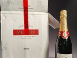 a bottle of champagne next to a box with a red ribbon