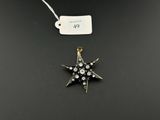 un pendentif en forme d'étoile en or et diamants, avec son étiquette de prix
