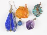 quatre pendentifs en pierre de couleurs différentes sur un fond blanc