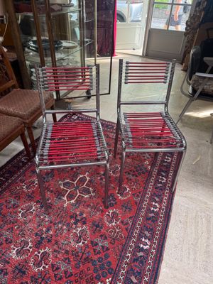 three chairs and a rug in a room with a red carpet