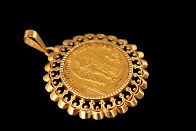 On voit l'image d'une pièce d'or sur fond noir.
