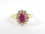 une bague en or sertie d'un rubis entouré de diamants blancs