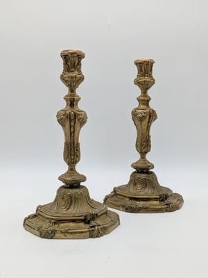 une paire de bougeoirs anciens en laiton sur fond blanc
