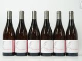 six bouteilles de vin alignées sur une table