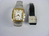 une montre argentée et dorée et une montre noire et blanche