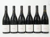 six bouteilles de vin sont alignées sur une surface blanche