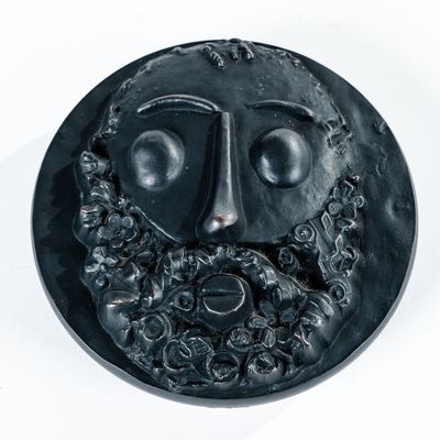 une image représentant une assiette noire sur laquelle figure le visage d'un homme