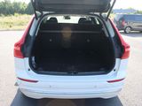 the back of a white car with its trunk open in a parking lot