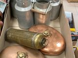 une boîte remplie de casseroles et de poêles en cuivre posée sur une table
