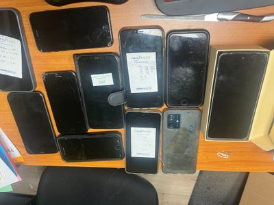 many cell phones that are sitting on a desk