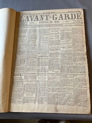 un vieux journal posé sur une table, à côté d'une tasse de café