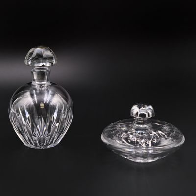 une paire de flacons de parfum en cristal taillé posés sur une surface noire