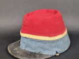 un chapeau rouge et bleu posé sur une surface noire