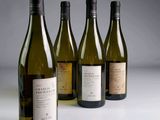 trois bouteilles de vin blanc sont alignées sur une table
