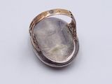 silver ring with a stone in the middle of it on a white surface