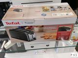un grille-pain posé sur une table en verre