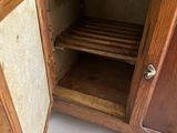 a wooden cabinet with a glass door and a shelf