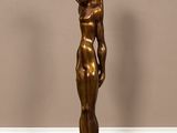 statue en bronze représentant un homme tenant un bébé dans ses bras, posée sur un socle noir