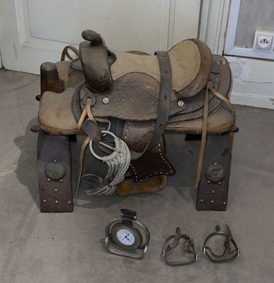 a horse saddle with a clock and other items on the floor