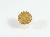 an image of a gold ring with a coin on it