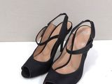 a pair of black high heeled shoes with straps on the toes