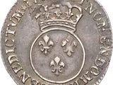 a close up of a silver coin with a crown on it