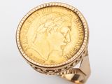 une image représentant une bague en forme de pièce d'or sur laquelle est gravé le visage d'une femme