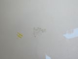 un mur blanc sur lequel il y a des traces de peinture jaune