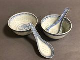two bowls with spoons in them sitting on a table