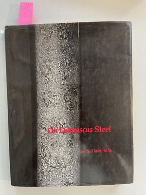 un livre noir avec des inscriptions rouges, posé sur une table