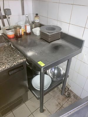 une cuisine équipée d'un évier, d'une cuisinière, d'un lave-vaisselle et d'autres éléments posés sur le plan de travail