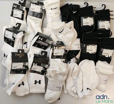 several pairs of white and black socks on display in a display case