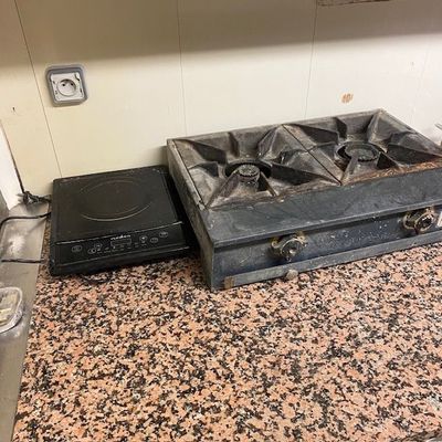 une plaque de cuisson noire posée sur un plan de travail en granit