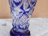 a blue glass vase on a table with a note on it