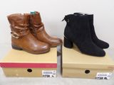 two pairs of women ' s boots are sitting on top of boxes