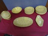 a table with a red table cloth and yellow dishes on it
