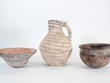 trois pièces de poterie posées les unes à côté des autres sur une surface blanche