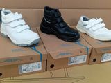 trois paires de chaussures posées sur une boîte en carton