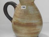 un vase marron et noir sur lequel est accrochée une étiquette
