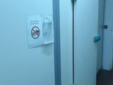 a bathroom with a toilet in it and a sign on the wall