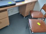 a desk with two chairs and a laptop on top of it