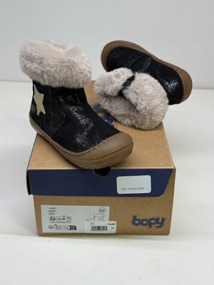 une paire de chaussures pour bébé dans une boîte posée sur une surface blanche