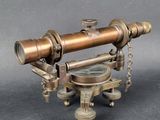 an antique brass telescope with a compass on a stand