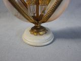 a white and gold vase with a clock on top of it