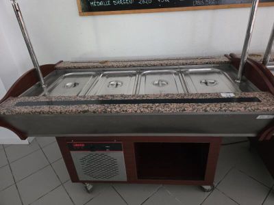 une table de buffet avec trois plats et un tableau noir accroché au mur