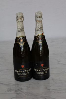 two bottles of champagne sitting on top of a marble counter top